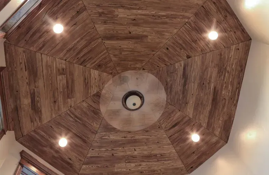 A wooden ceiling with a circular design and lights on it