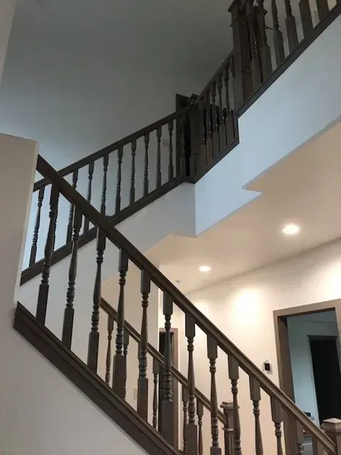 A staircase with a wooden railing going up to the second floor