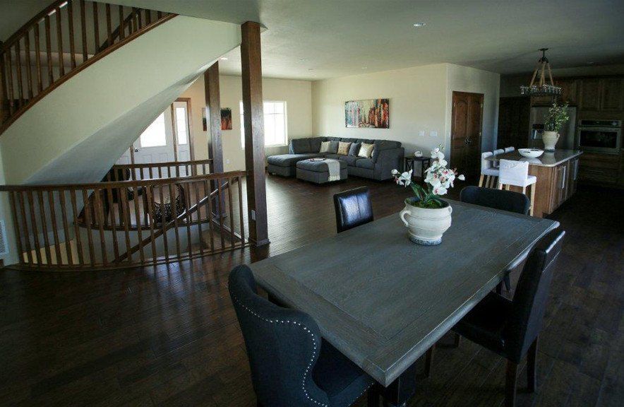 A living room with a table and chairs and a staircase
