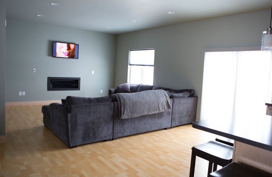 A living room with a couch and a television on the wall