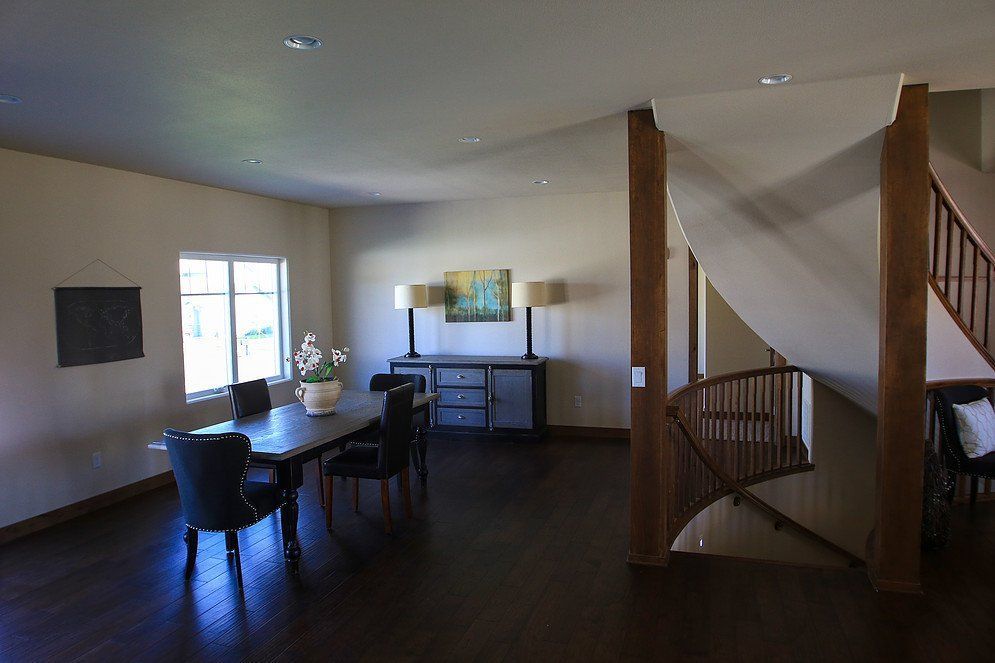 A dining room with a table and chairs and a spiral staircase