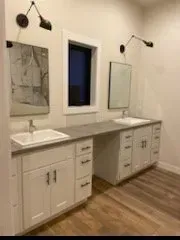 A bathroom with two sinks and two mirrors.