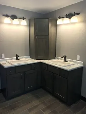 A bathroom with a toilet, sink, and handrails.