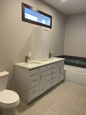A bathroom with a toilet, sink, and vanity.