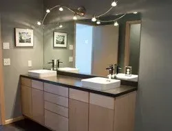 A bathroom with two sinks and a large mirror.