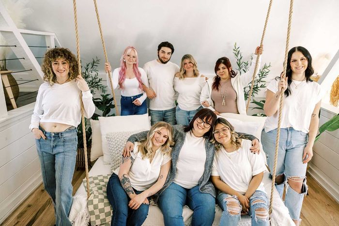 A group of people are posing for a picture while sitting on a swing.