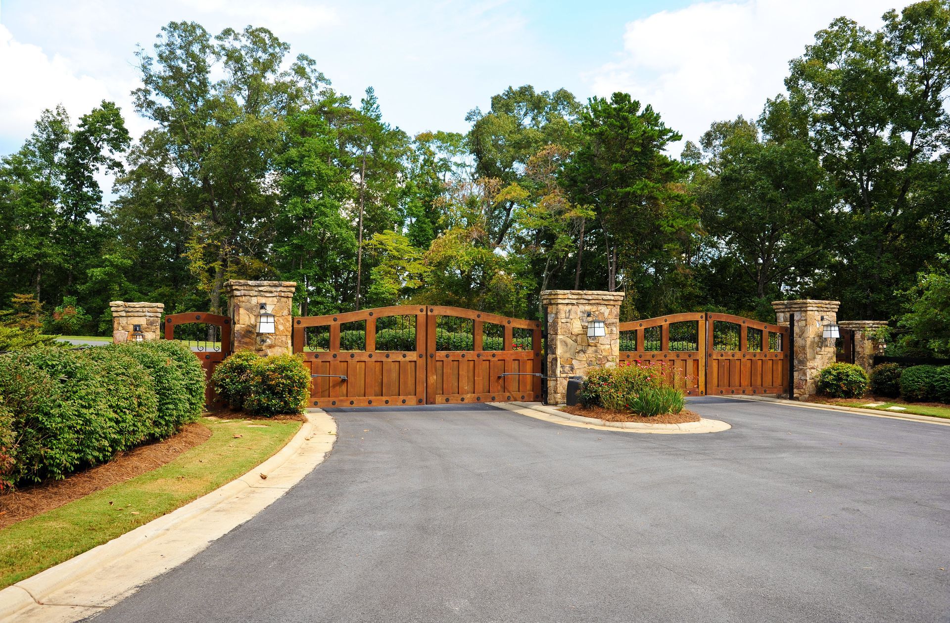 Black metal fence surrounding a pool and yard, with trees in the background.