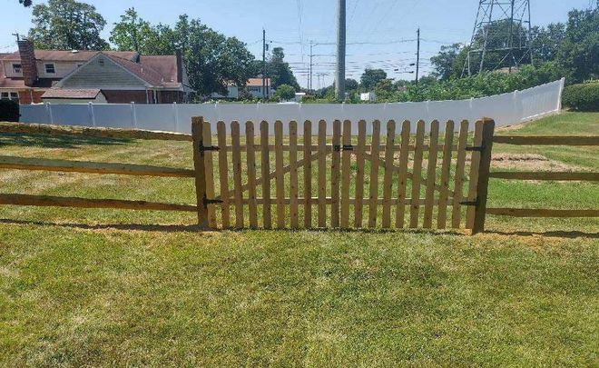White picket fence along a beige house with a curved design.