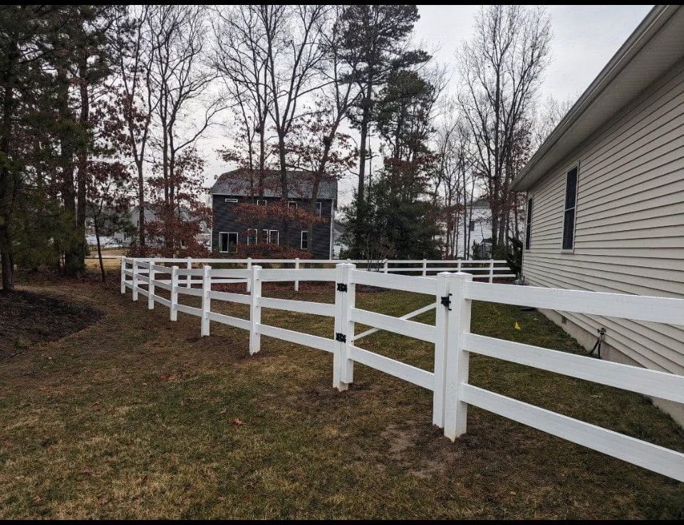 White picket fence along a beige house with a curved design.