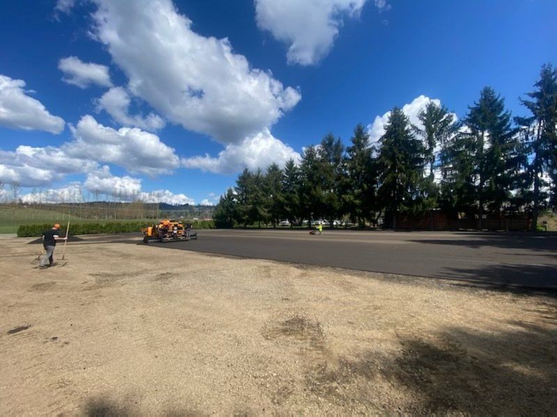 A tractor is driving down a dirt road in a field.