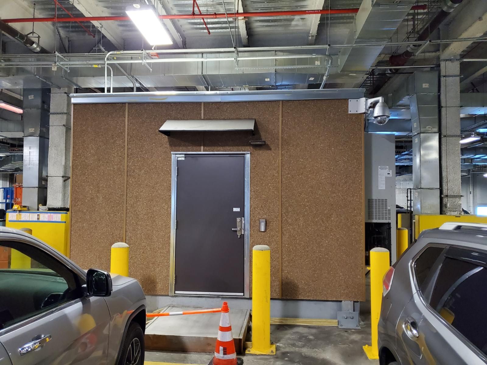 Two cars are parked in front of a building with a door