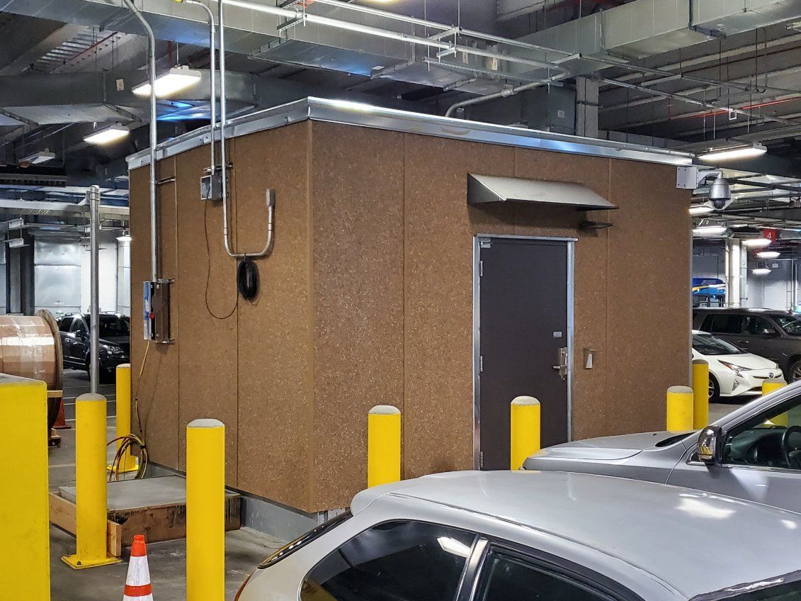A car is parked in front of a building in a parking garage.
