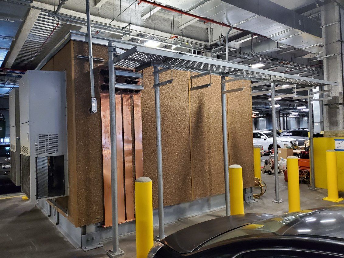 A car is parked in front of a building under construction.