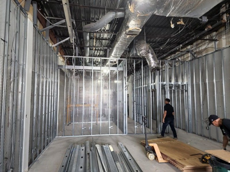 A man is standing in a room that is being built