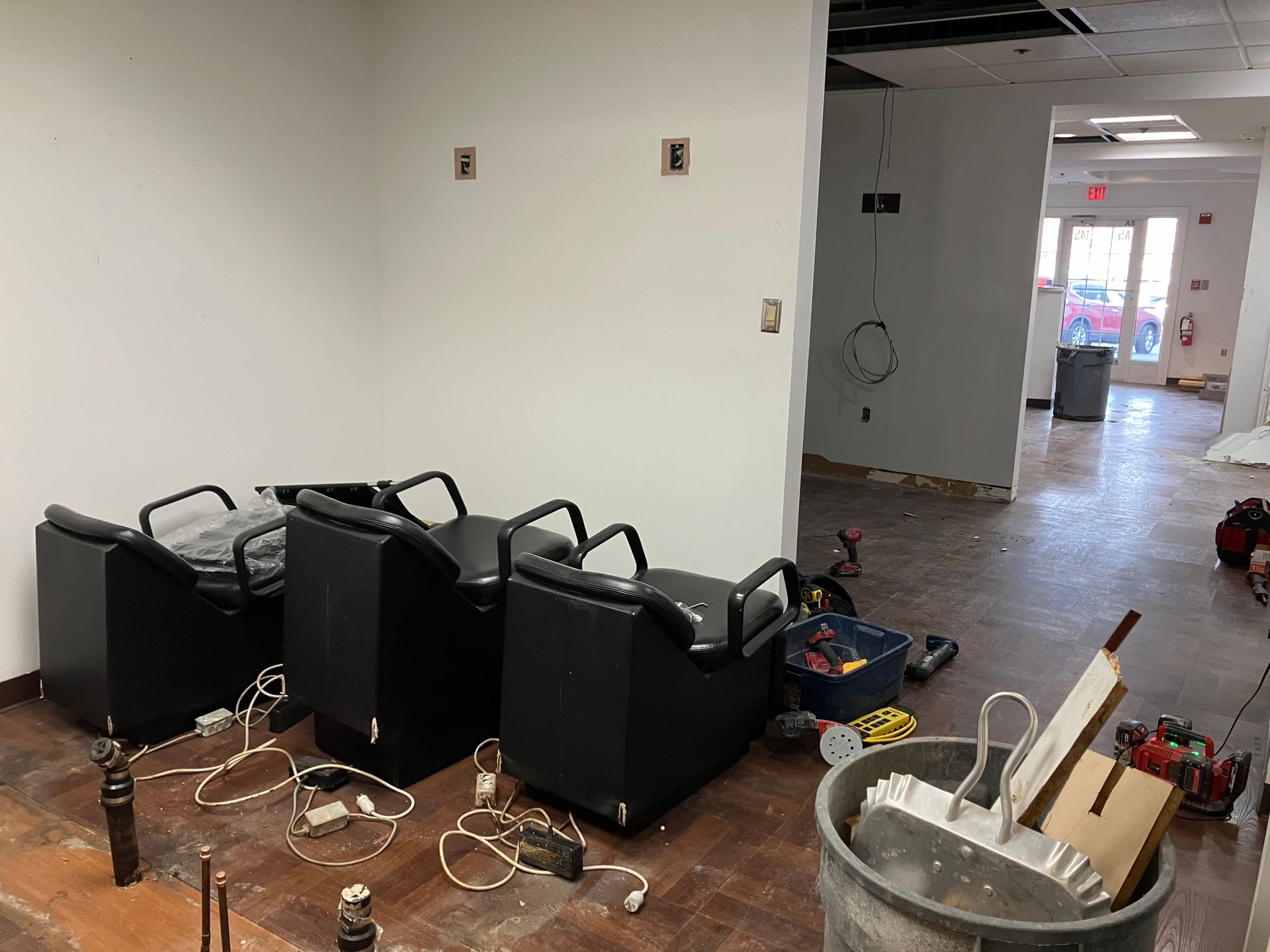 A room with chairs and a trash can close to it