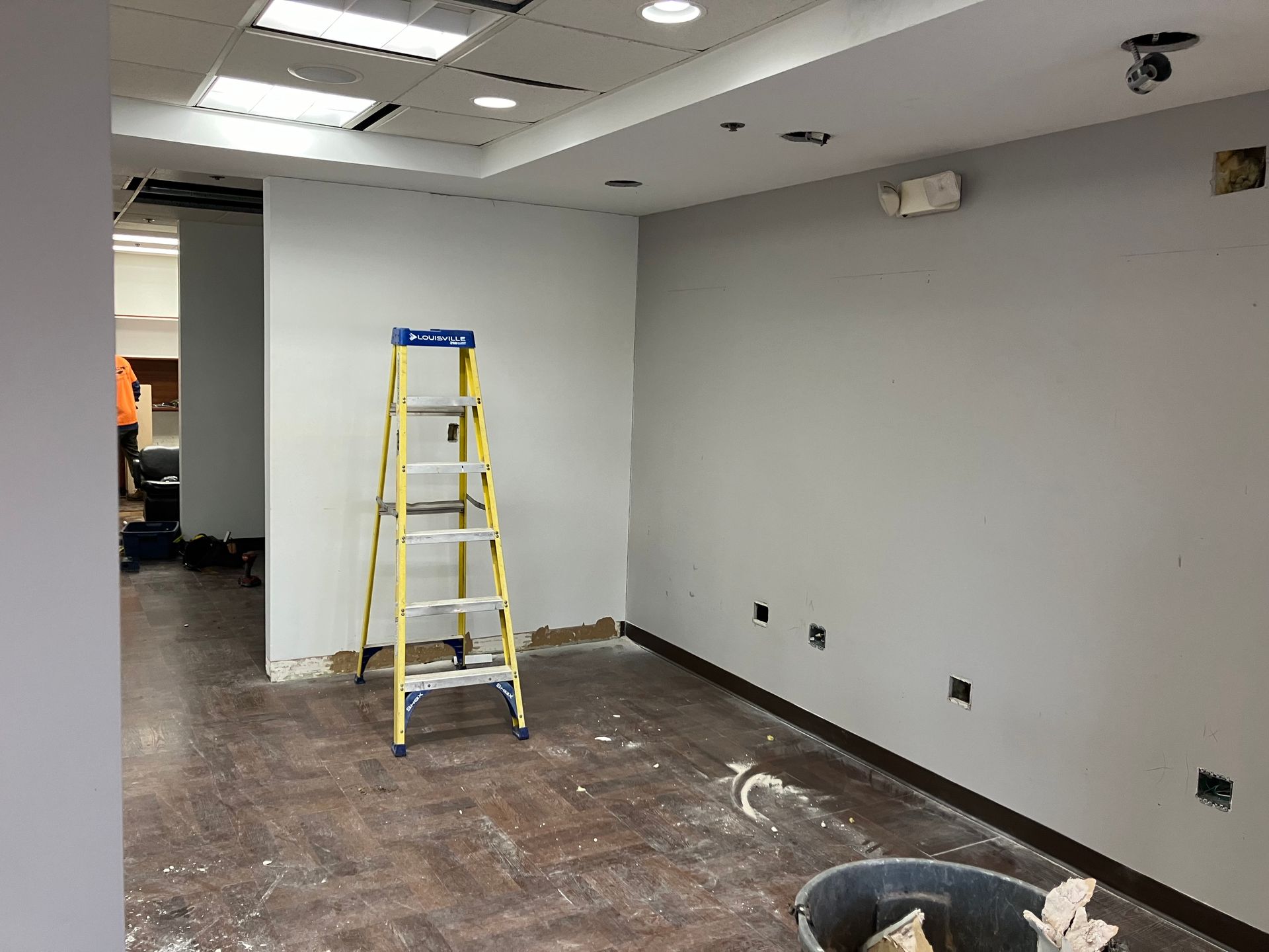 An empty room with a ladder in the middle of it.