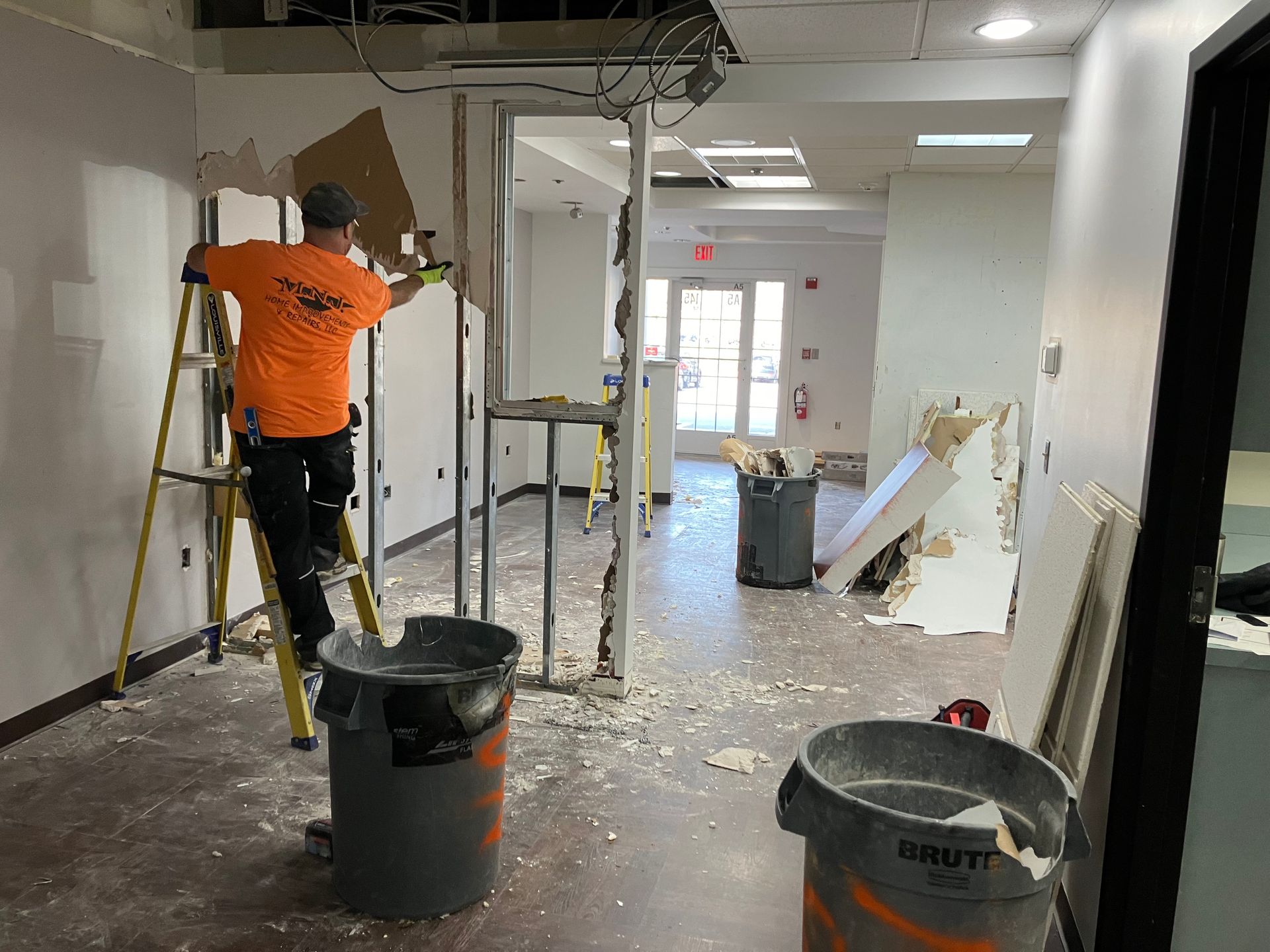 A man is standing on a ladder in a room.