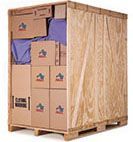 Wooden shipping container packed with cardboard boxes.
