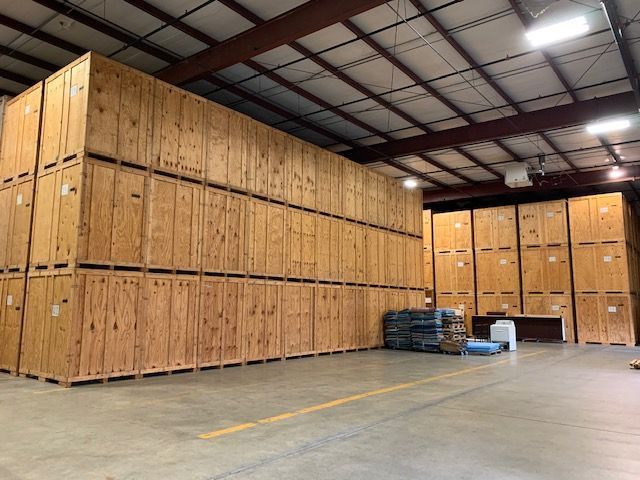 Large warehouse with many stacked wooden storage containers.