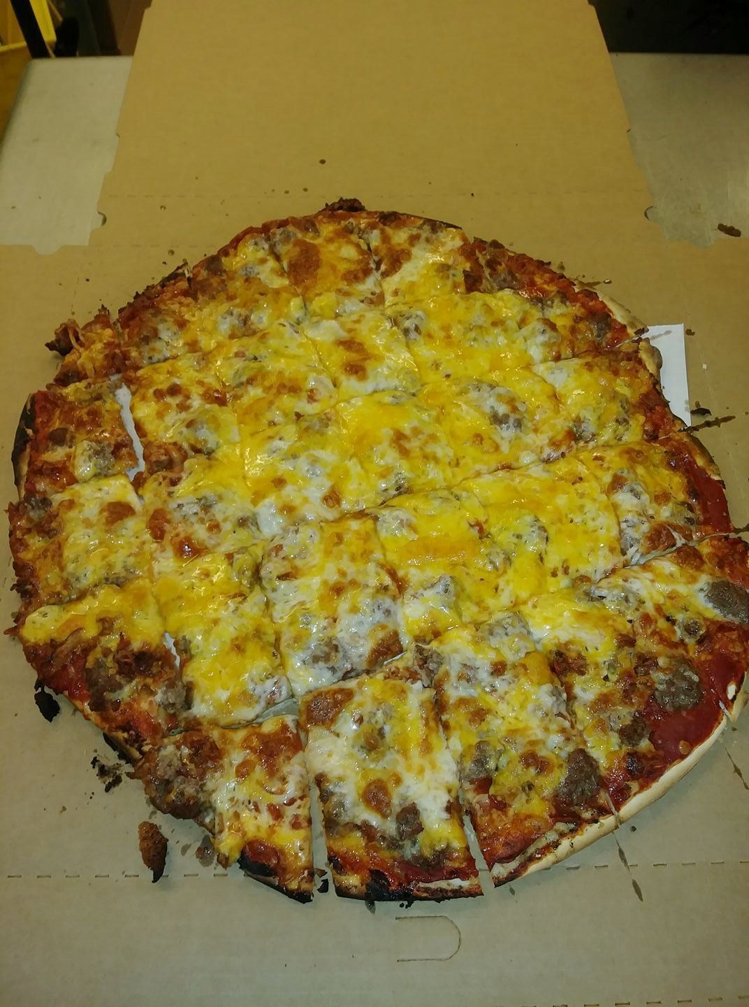 Cheese and pepperoni pizza in a cardboard box, topped with melted cheese