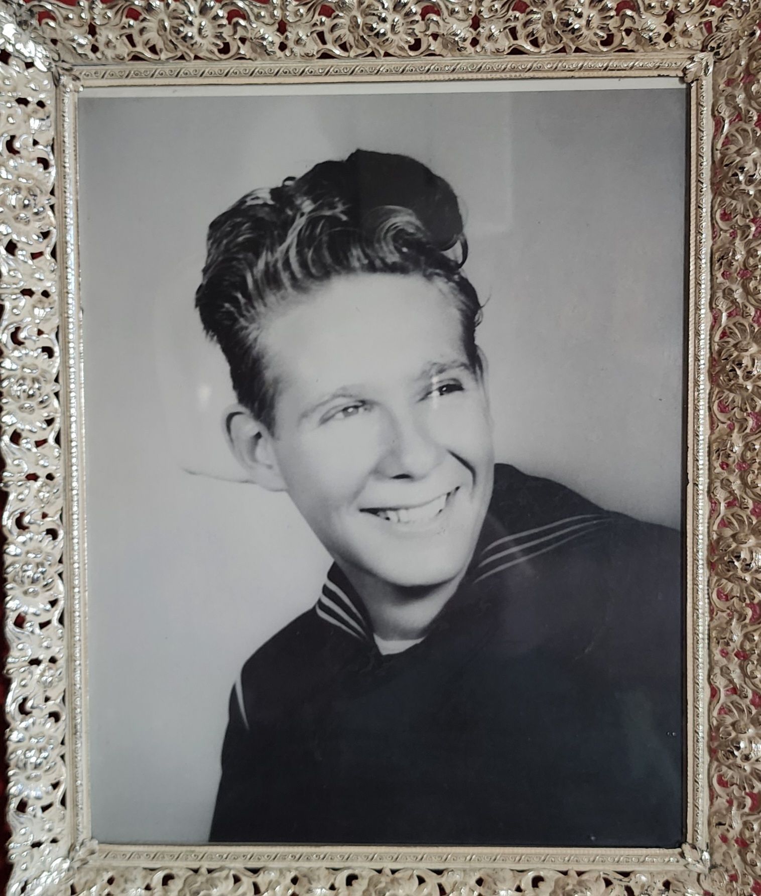 Black-and-white portrait of a smiling person in a decorative frame