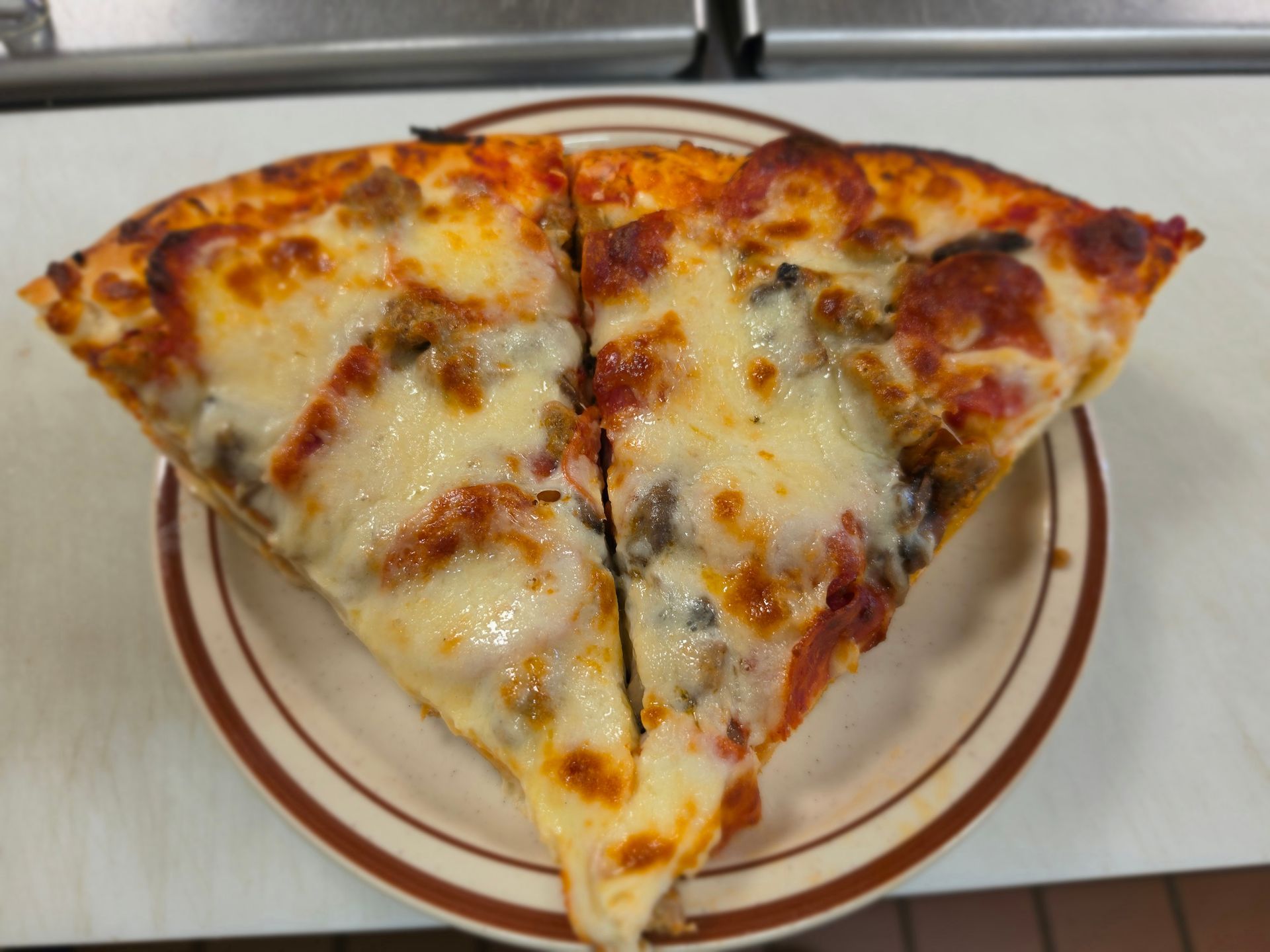 Two slices of cheese pizza on a white plate
