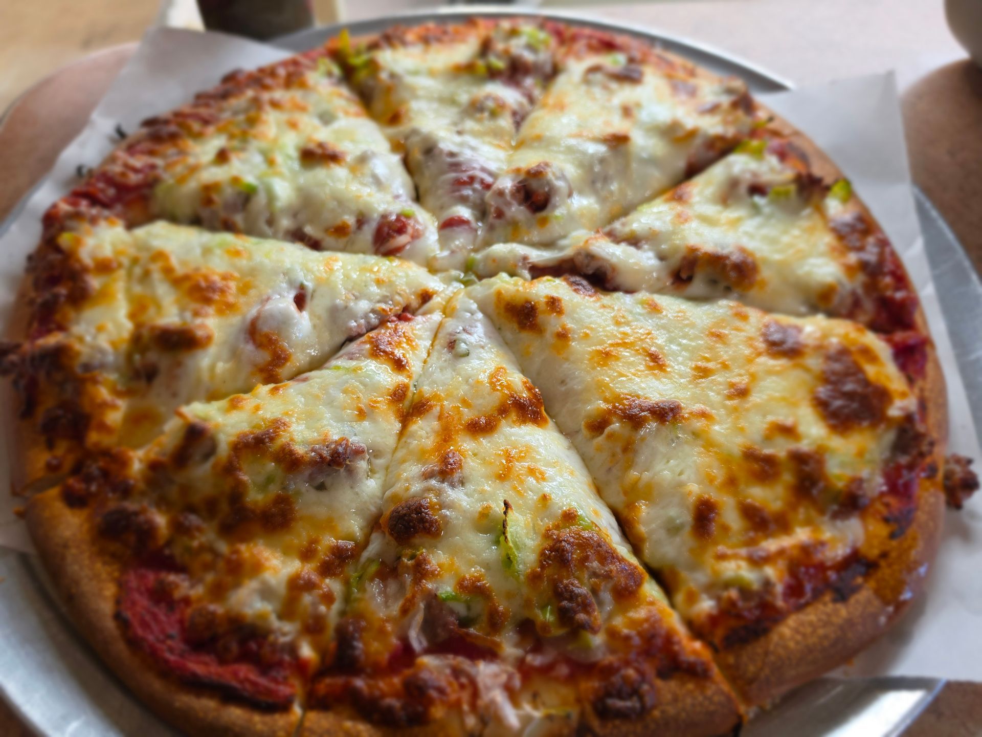 Cheese pizza with eight slices on a white plate, golden melted cheese and browned crust