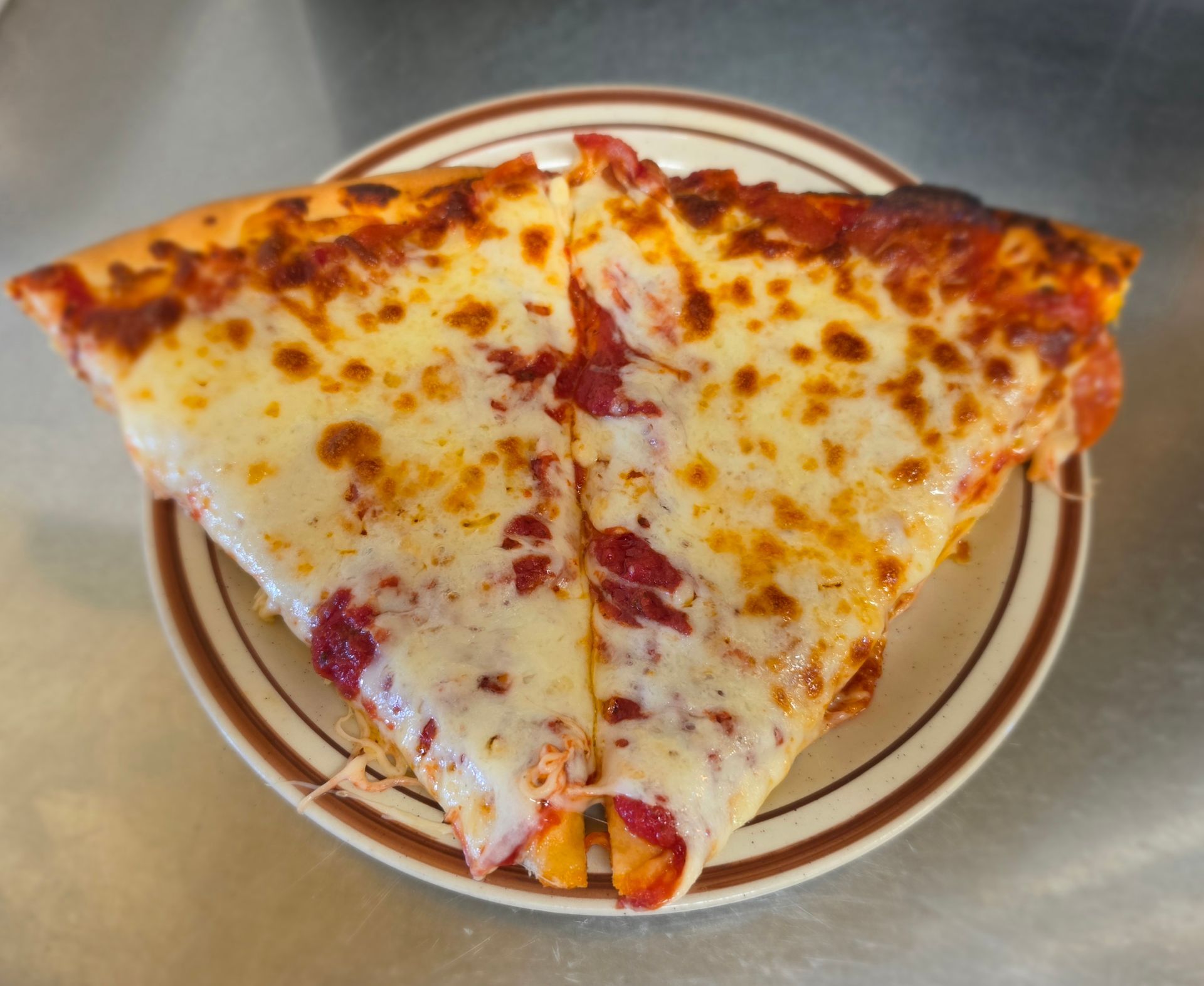 Two slices of cheese pizza on a paper plate