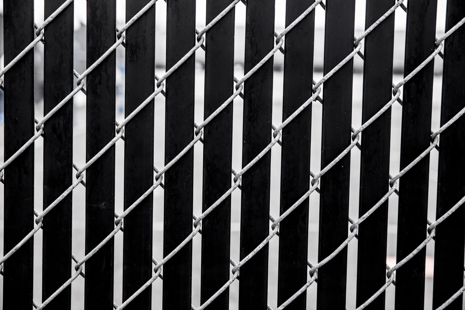 A close up of a metal fence with a black background.