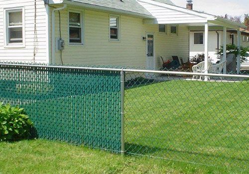 A chain link fence in front of a house