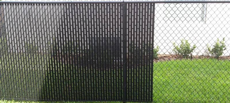 A chain link fence with a black fence in front of it.