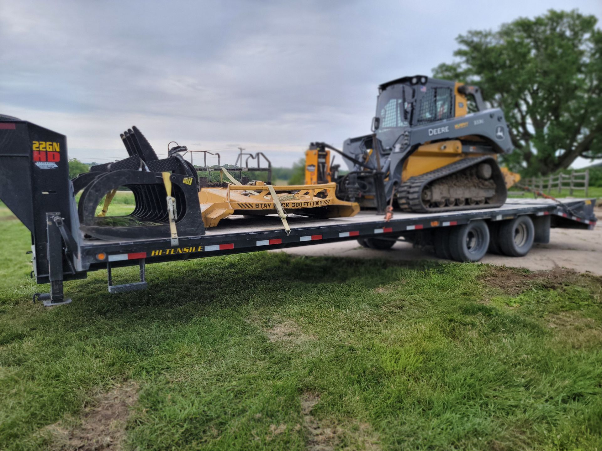 A bulldozer is sitting on top of a trailer in a field.
