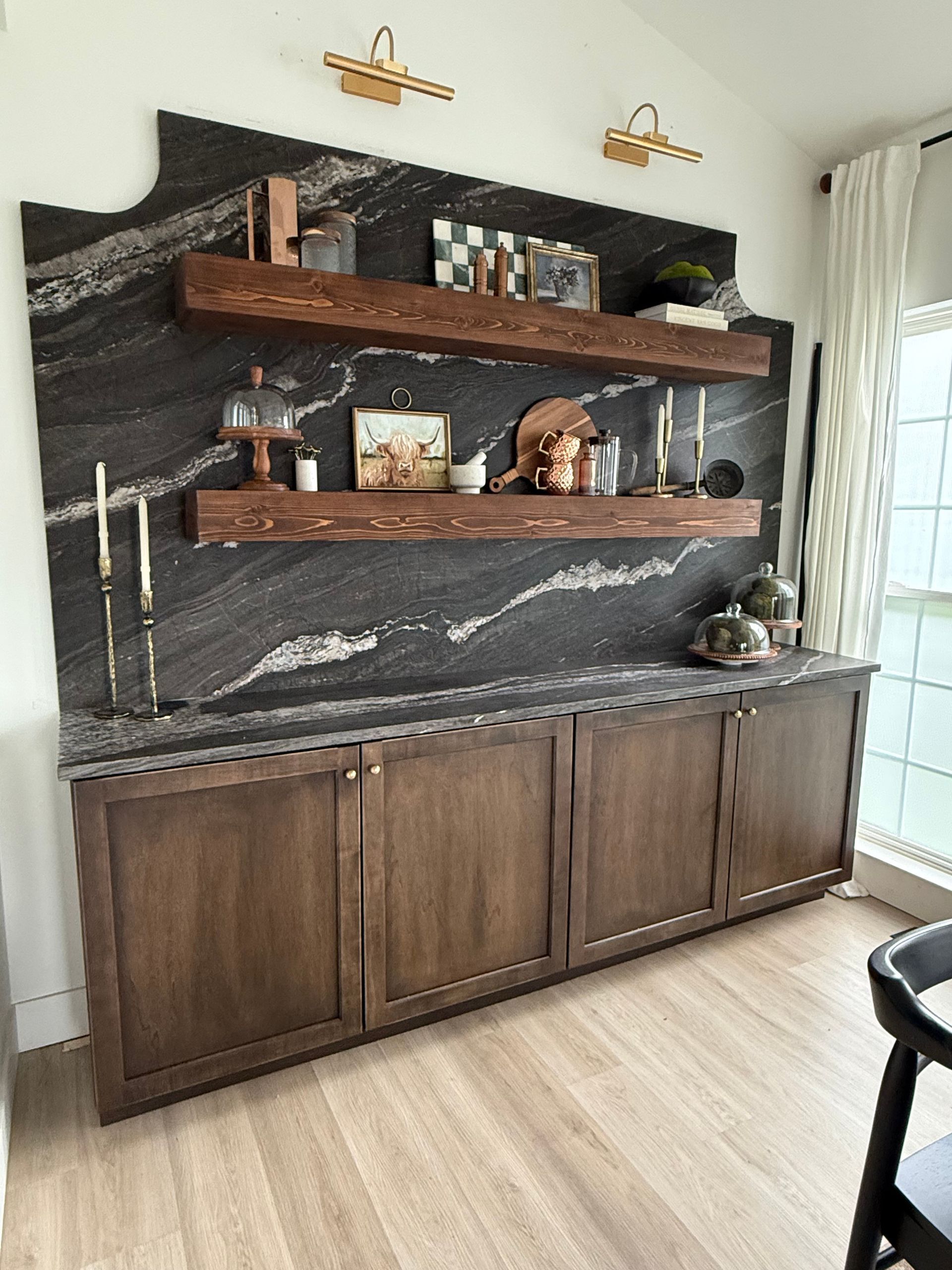 Modern living room wall unit with dark wood cabinets, floating shelves, and decorative items on a stone accent wall