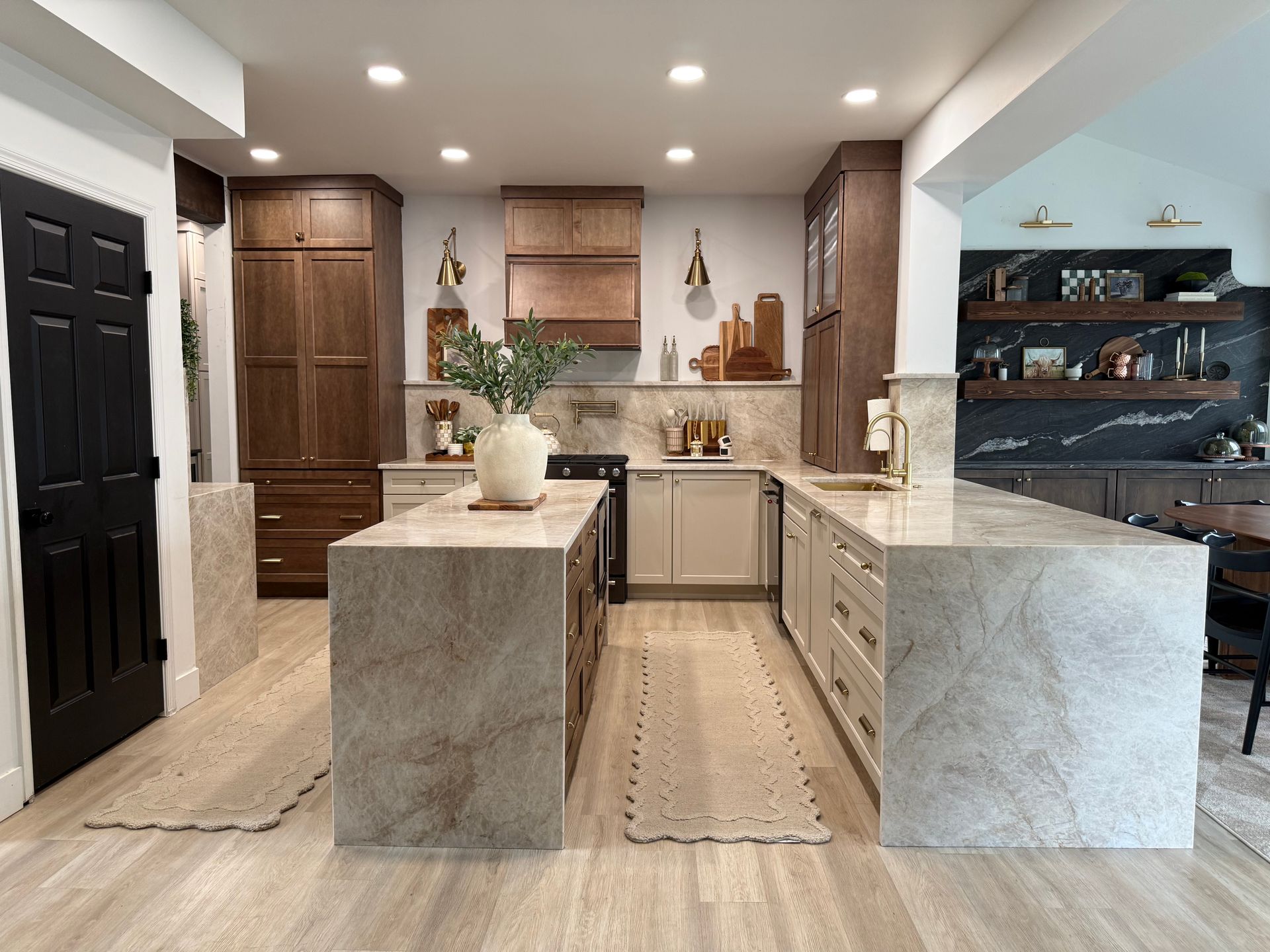 Modern kitchen with large stone island, wood cabinetry, and recessed lighting