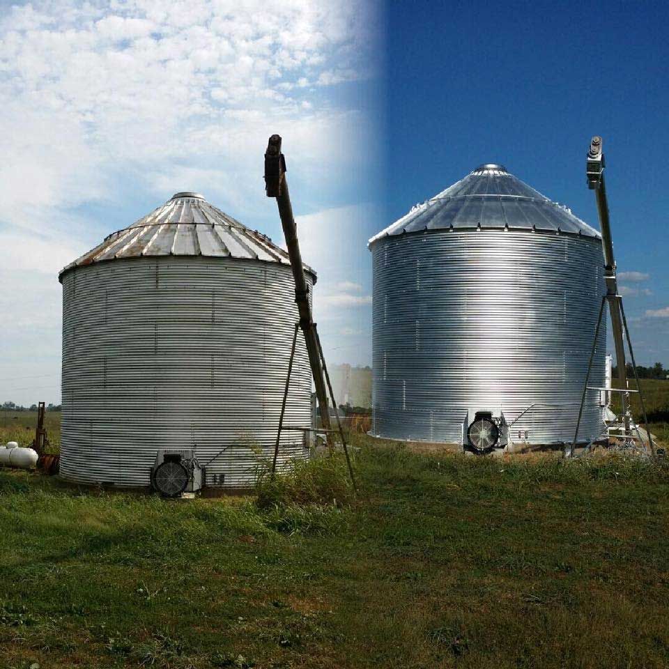 Two silos in a grassy field with a blue sky in the background