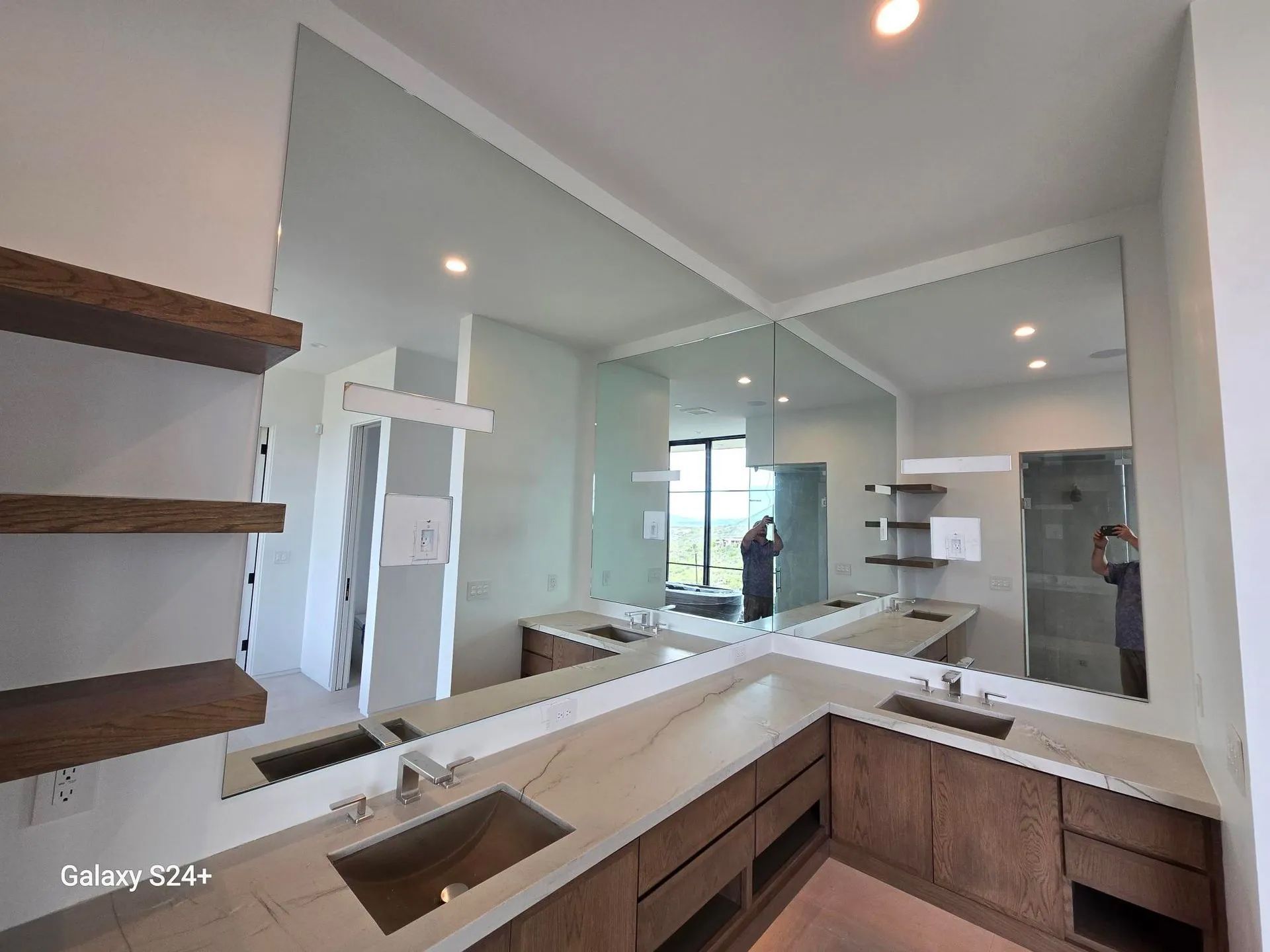 A bathroom with two sinks and a large mirror.