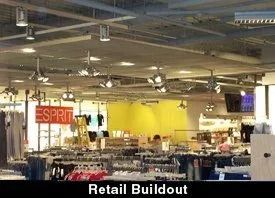 Retail store interior under construction with exposed ceiling, bright yellow wall, and ESPRIT sign.