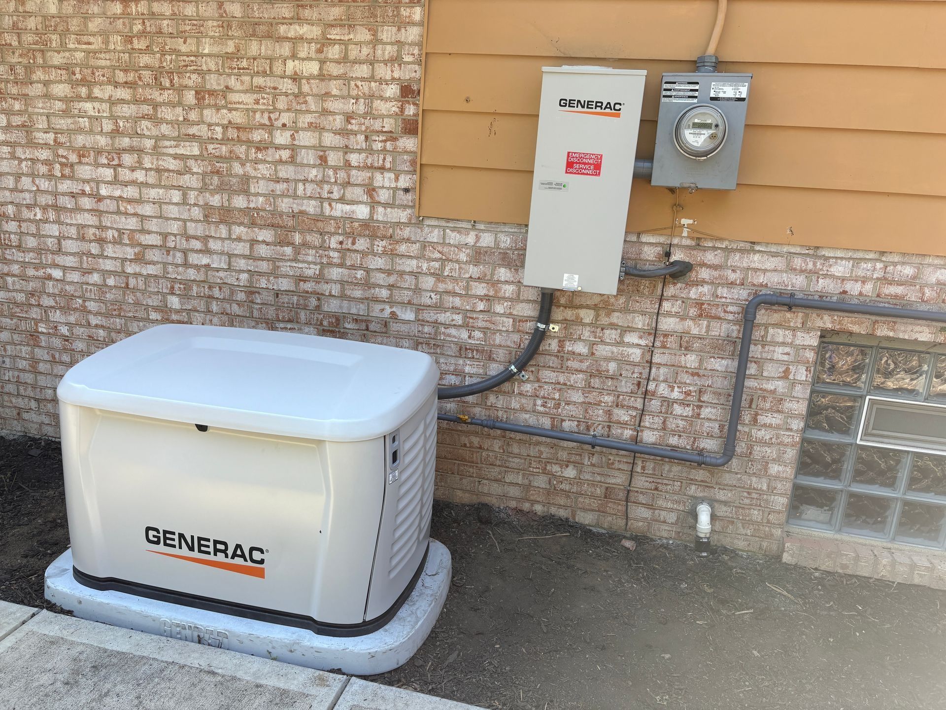 Backup generator beside a brick house with electrical meter and conduit lines
