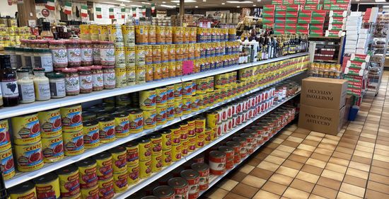 Shelves stocked with canned goods and jars in a grocery store aisle.