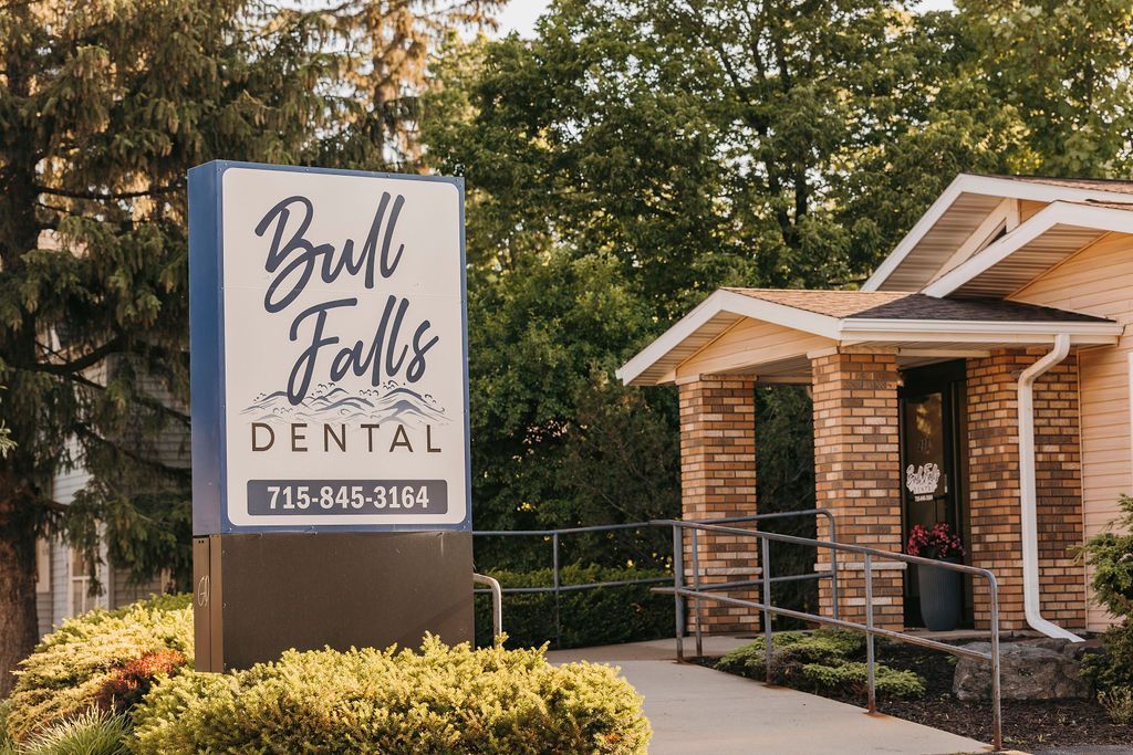 A dental office with a sign in front of it.