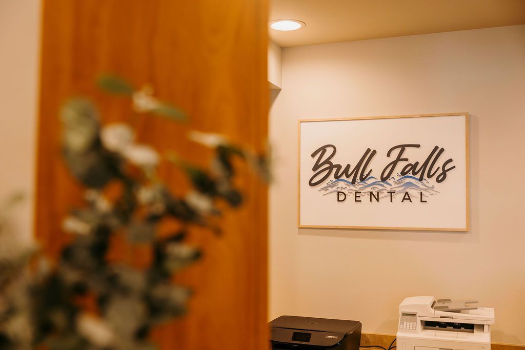 A dental office with a sign on the wall and a printer.