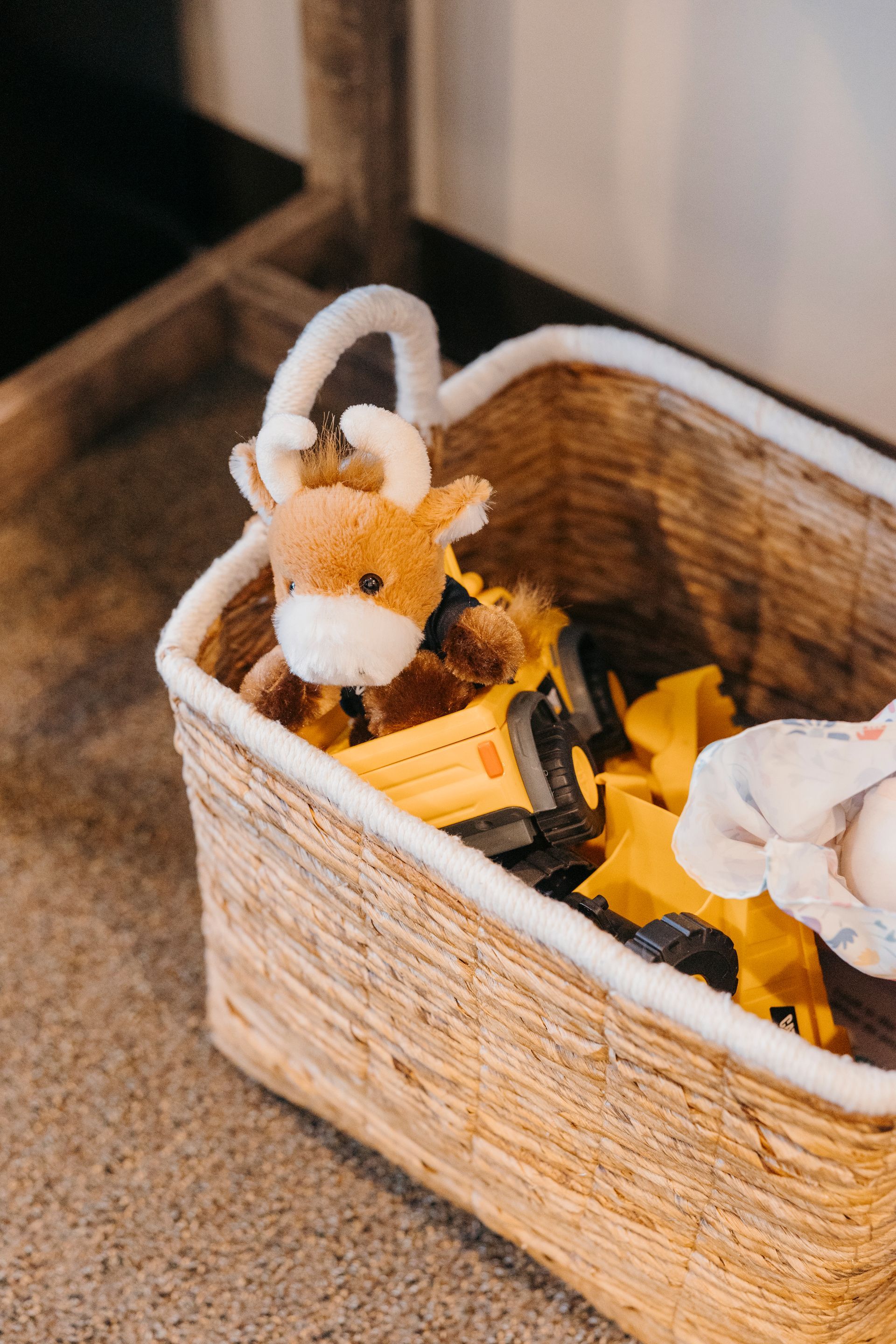 A basket filled with stuffed animals and a toy truck.