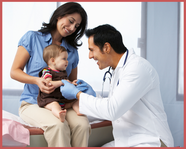 Doctor examining a baby while a parent smiles in a clinic room