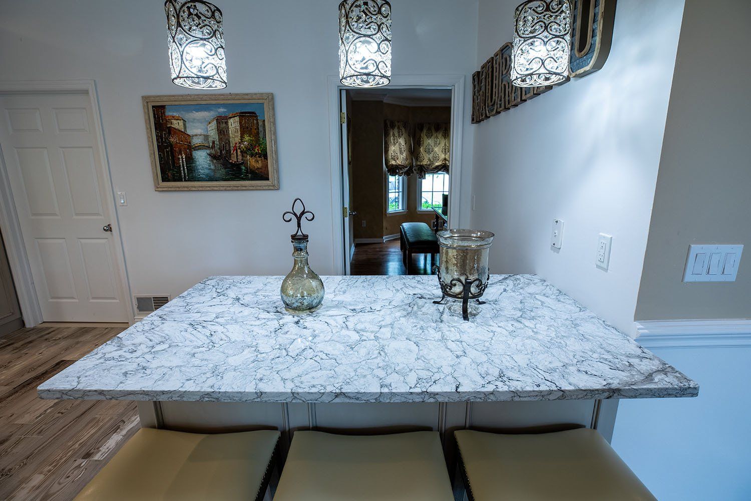 There is a table with a vase on it in the middle of the room.