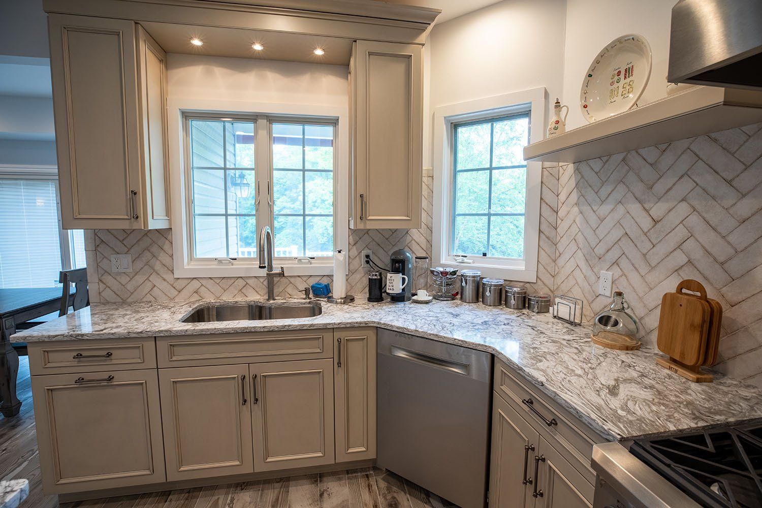 A kitchen with white cabinets , granite counter tops , stainless steel appliances and a sink.