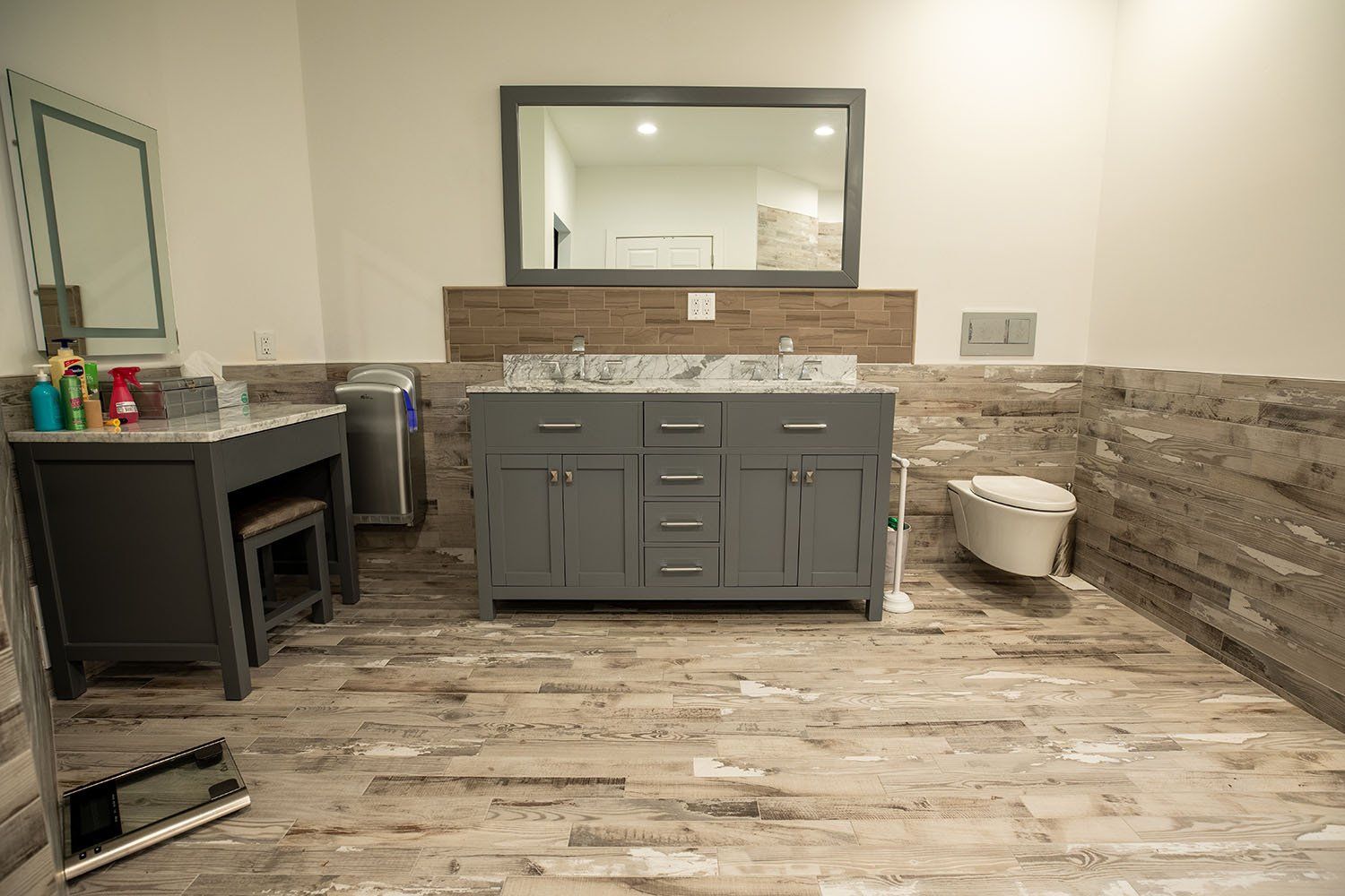 A bathroom with two sinks , a toilet , and a mirror.