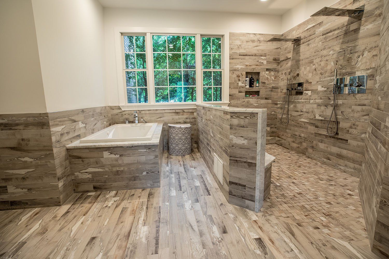 A bathroom with a tub and a walk in shower.