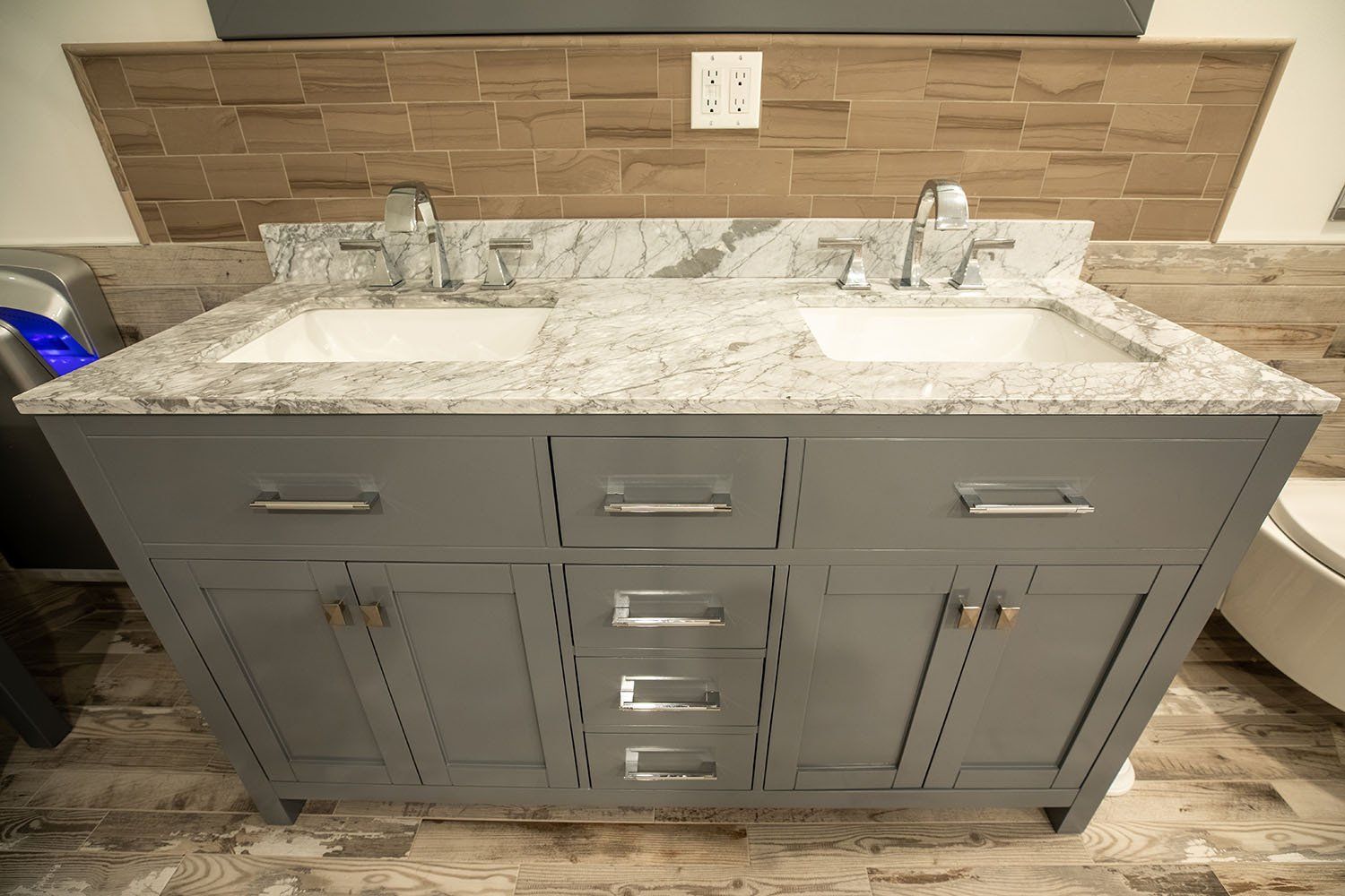 A bathroom vanity with two sinks and a granite counter top.