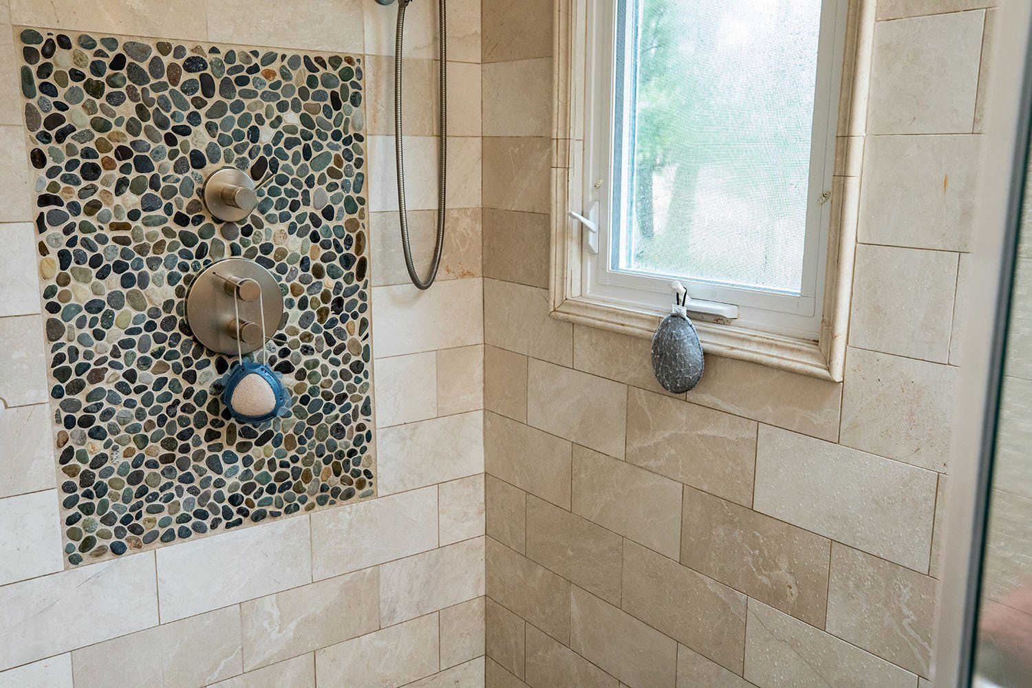 A bathroom with a walk in shower and a window.