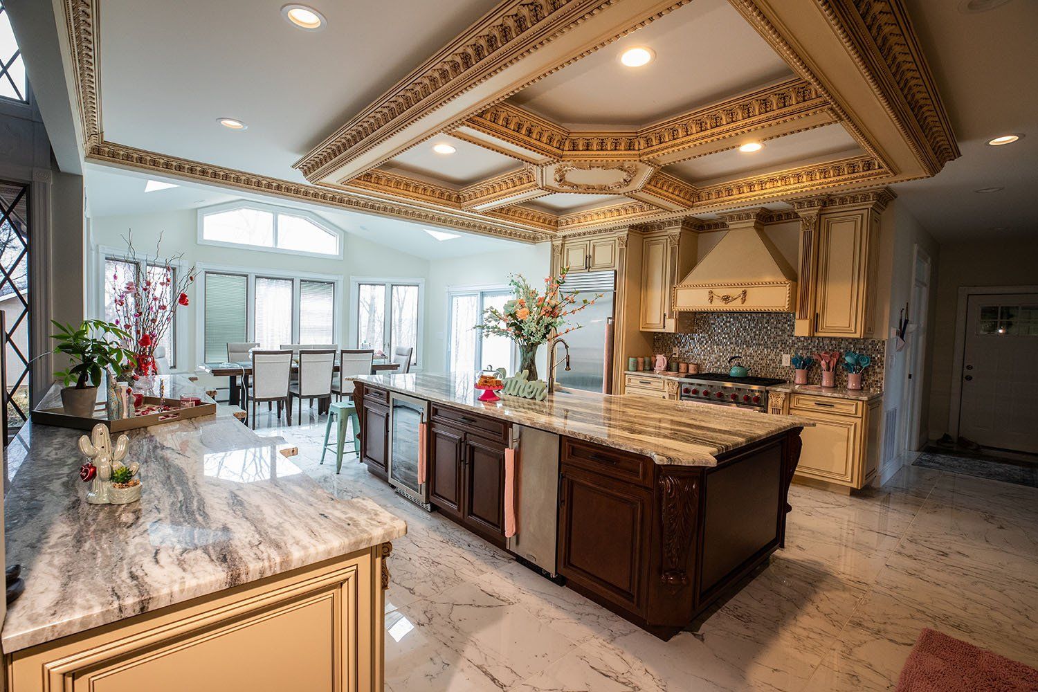 A kitchen with a large island in the middle and a dining room in the background.